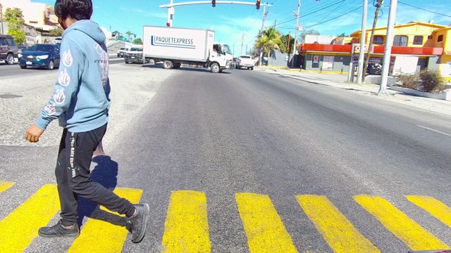 LOS CABOS BCS MEXICO-2022: Person Crossing Road As Vehicles Pass by
