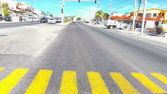 LOS CABOS BCS MEXICO-2022: Vehicles Moving Through Urban Intersection with Yellow Crosswalk