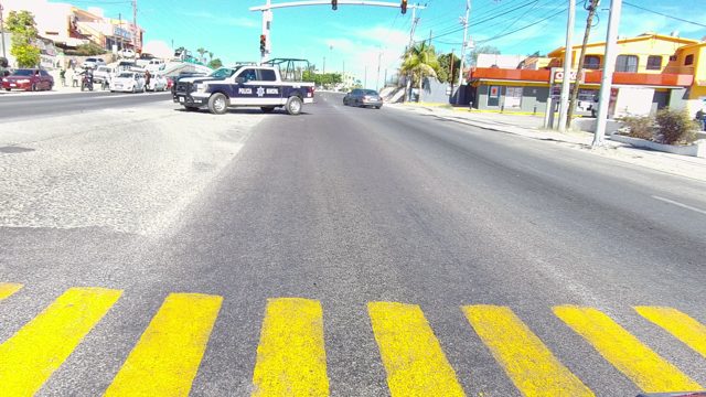 LOS CABOS BCS MEXICO-2022: Police Vehicle and Traffic Moving Through Intersection
