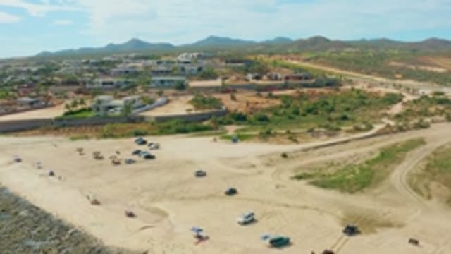 EL TULE LOS CABOS BCS MEXICO-2022: Sandy Beach Clearing with Departing Vehicles and People
