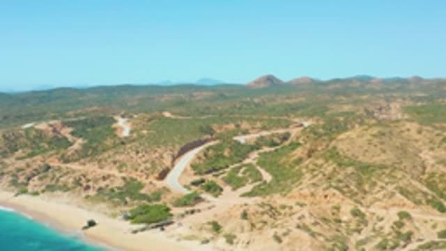 EL TULE LOS CABOS BCS MEXICO-2022: Car Moving Along Winding Coastal Mountain Road