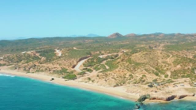 EL TULE LOS CABOS BCS MEXICO-2022: Vehicle Traveling Along Sandy Beach by Coastal Hills