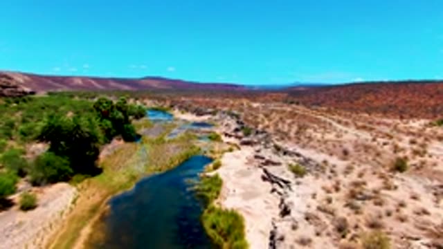 SAN JUANICO BCS MEXICO-2022: Arid River with Vehicle Passing on Road