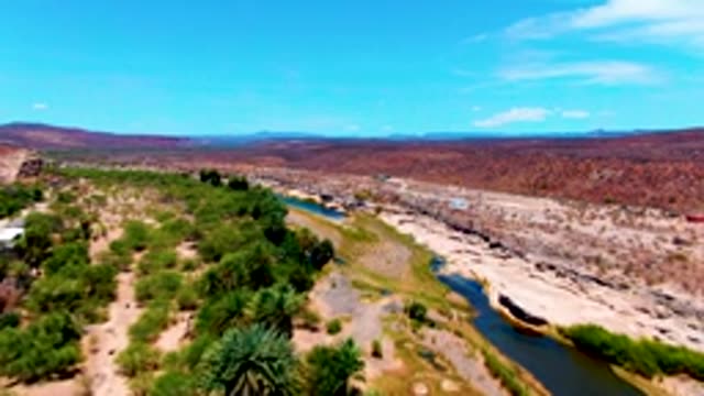 SAN JUANICO BCS MEXICO-2022: River Winding Through Arid, Tree-Dotted Terrain