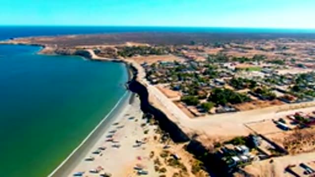 SAN JUANICO BCS MEXICO-2022: Vehicle Moving Along Coastal Road Beside Sandy Beach