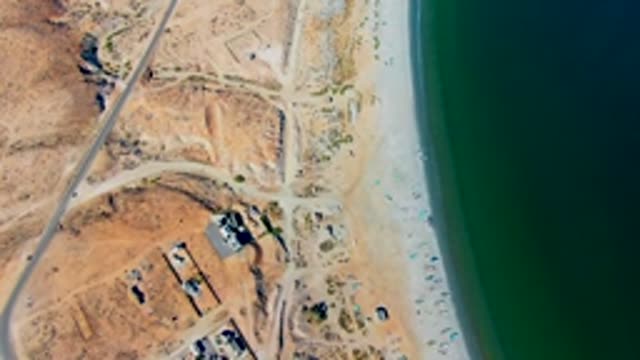 SAN JUANICO BCS MEXICO-2022: Car Driving on Coastal Road by Sandy Beach