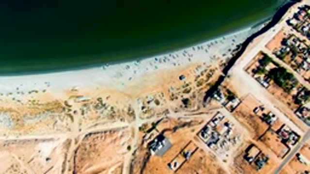 SAN JUANICO BCS MEXICO-2022: Beachgoers on Shore Near Residential Neighborhood
