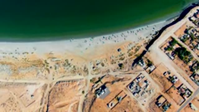 SAN JUANICO BCS MEXICO-2022: Beachgoers Gradually Leaving Sandy Shore near Coastal Development