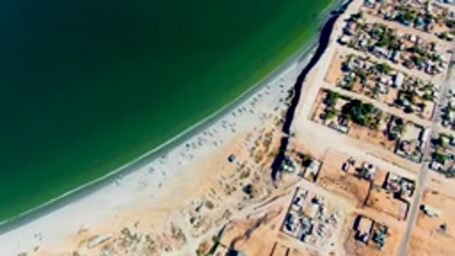 SAN JUANICO BCS MEXICO-2022: Receding Ocean Water Along Sandy Beach and Coastal Development