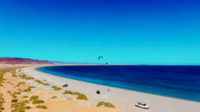 SAN JUANICO BCS MEXICO-2022: Kite Surfer Gliding on Sandy Beach
