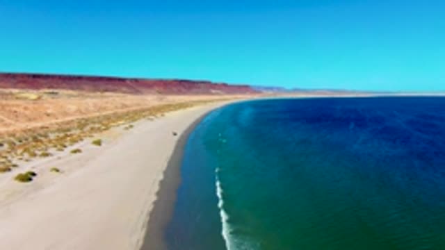 SAN JUANICO BCS MEXICO-2022: Vehicle Driving Along Desert Beach Shoreline