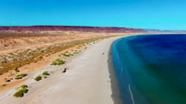 SAN JUANICO BCS MEXICO-2022: Car Driving Along Sandy Beach with Dunes and Ocean