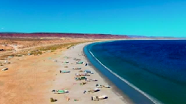 SAN JUANICO BCS MEXICO-2022: Fishing Boats Hauled on Sandy Beach with Desert Backdrop