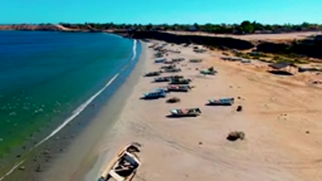 SAN JUANICO BCS MEXICO-2022: Fishing Boats Lined on Sandy Beach with Ocean Waves
