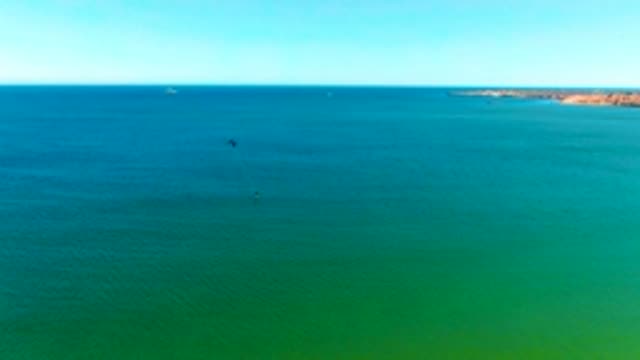 SAN JUANICO BCS MEXICO-2022: Kitesurfers Gliding Over Turquoise Ocean