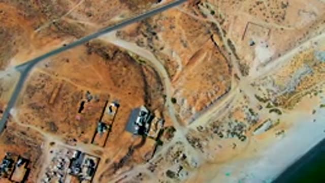SAN JUANICO BCS MEXICO-2022: Car Moving on Arid Desert Road Near Settlement