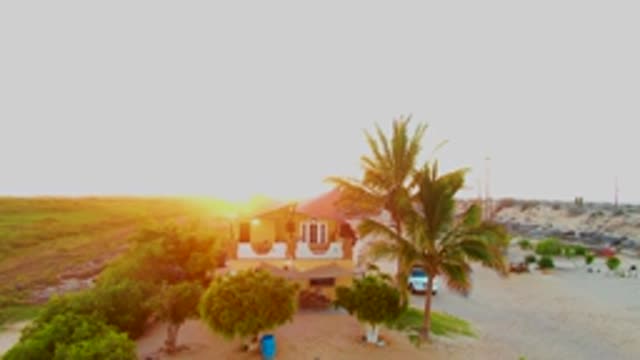 SAN CARLOS BCS MEXICO-2022: Coastal House at Sunset with Passing Vehicles