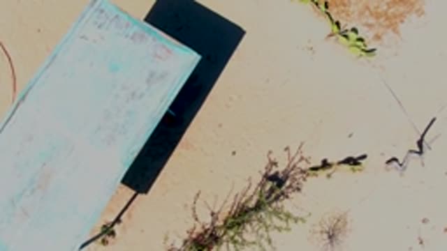 SAN CARLOS BCS MEXICO-2022: Weathered Blue Platform on Sandy Ground with Camera Zoom