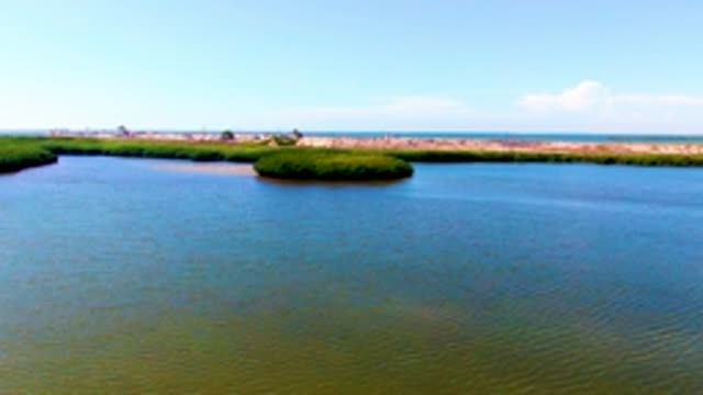 SAN CARLOS BCS MEXICO-2022: Calm Waterway with Small Green Island and Rippling Surface