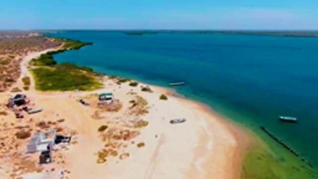 SAN CARLOS BCS MEXICO-2022: Sandy Coastline with Calm Waters and Small Buildings