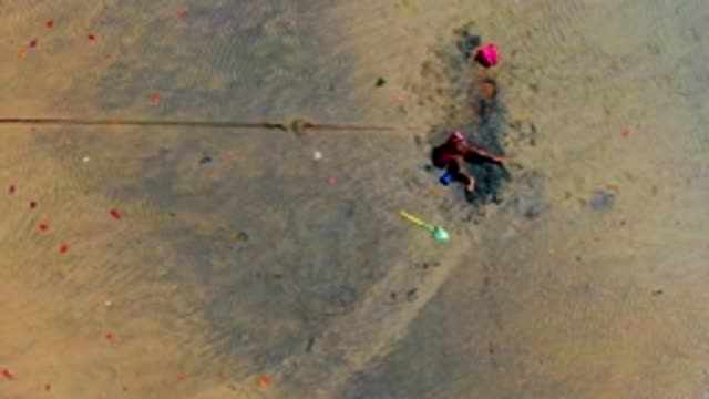 SAN CARLOS BCS MEXICO-2022: Child Playing in Wet Sand with a Shovel