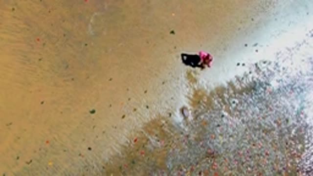 SAN CARLOS BCS MEXICO-2022: Person Wading Through Shallow Water with Floating Debris