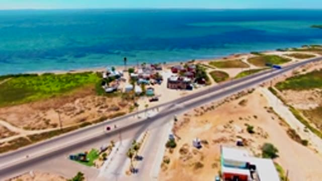 SAN CARLOS BCS MEXICO-2022: Coastal Highway Traffic with Beachside Buildings