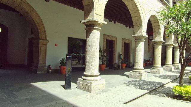 Stone Arch Courtyard with Potted Plants and Trees