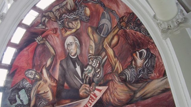 Mural of Historical Figure with Chained Figures and Liberty Document