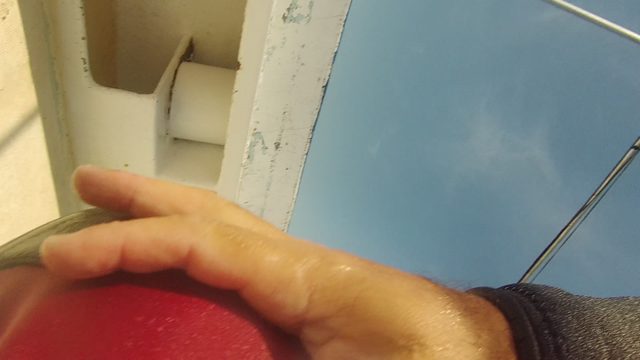 Person Adjusting Wetsuit on Boat Deck