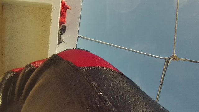 Person in Red Life Jacket Near Boat Structure with Moving Fabric