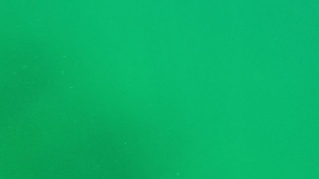 Dust Particles Drifting Across Green Background