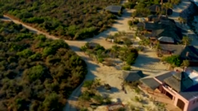 LAS BARRACAS EAST CAPE BCS MEXICO-2022: Winding Dirt Road Through Thatched Huts and Dense Bushes
