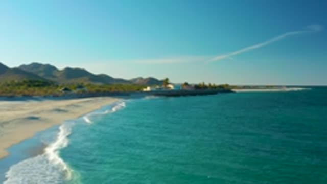 LAS BARRACAS EAST CAPE BCS MEXICO-2022: Waves Rolling Onto a Sandy Beach with Clear Turquoise Water