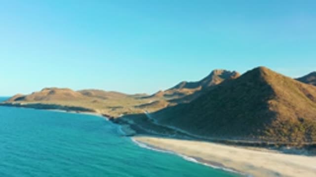 LAS BARRACAS EAST CAPE BCS MEXICO-2022: Hills Overlooking Sandy Beach and Turquoise Ocean