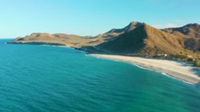 LAS BARRACAS EAST CAPE BCS MEXICO-2022: Sandy Beach and Mountain Coast with Vanishing Boat