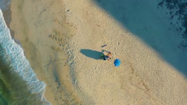 LAS BARRACAS EAST CAPE BCS MEXICO-2022: Beachgoer with Blue Umbrella and Receding Waves