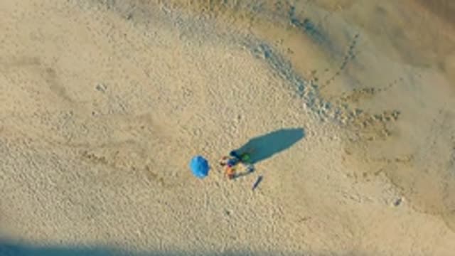 LAS BARRACAS EAST CAPE BCS MEXICO-2022: People Relaxing Under Blue Umbrella on Sandy Beach