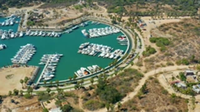 PUERTO LOS CABOS BCS MEXICO-2022: Marina with Docked Boats and Moving Vehicles on Road