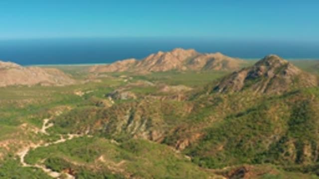 EL SALADO VIEJO LOS CABOS BCS MEXICO-2022: Vehicle Moving Along Valley Dirt Road in Mountain Landscape