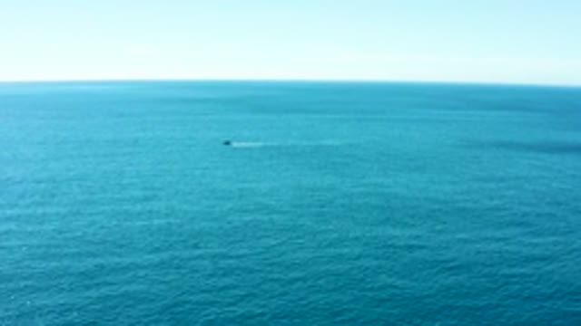 BUZZARDS EAST CAPE LOS CABOS BCS MEXICO-2022: Watercraft Creating Spray on Calm Ocean Surface