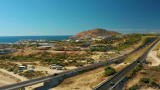 CHILENO BEACH LOS CABOS BCS MEXICO-2022: Vehicles Moving on Coastal Highway and Bridge near Hill