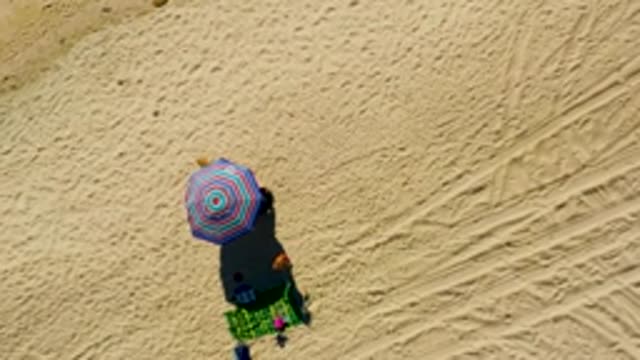 CHILENO BEACH LOS CABOS BCS MEXICO-2022: Person Leaving Beach Umbrella and Towel Setup
