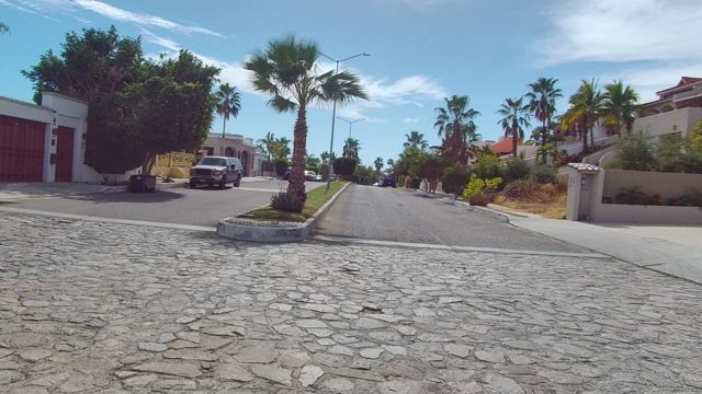 EAST CAPE LOS CABOS BCS MEXICO-2022: Vehicle Moving Along Palm-lined Residential Street
