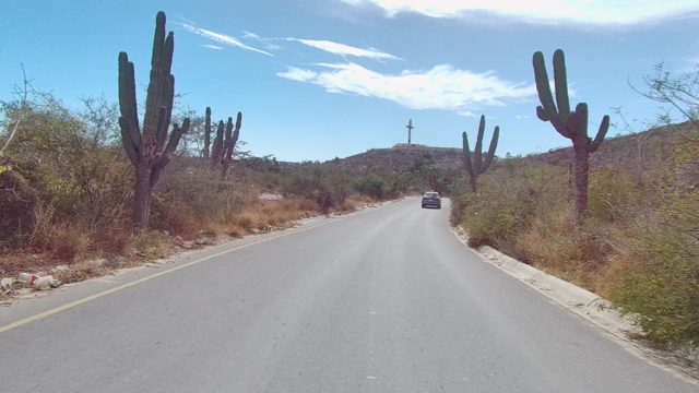 EAST CAPE LOS CABOS BCS MEXICO-2022: Car Driving on Arid Desert Road with Cacti