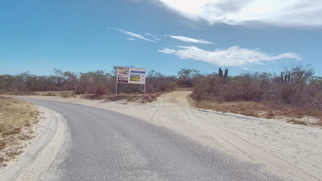 EAST CAPE LOS CABOS BCS MEXICO-2022: Car Moving Along Sandy-shouldered Road in Arid Area