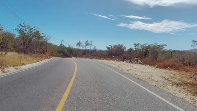 EAST CAPE LOS CABOS BCS MEXICO-2022: Vehicle Traveling on Winding Rural Road Through Dry Terrain