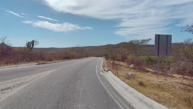 EAST CAPE LOS CABOS BCS MEXICO-2022: Paved Road Winding Through Arid Hills and Sparse Vegetation