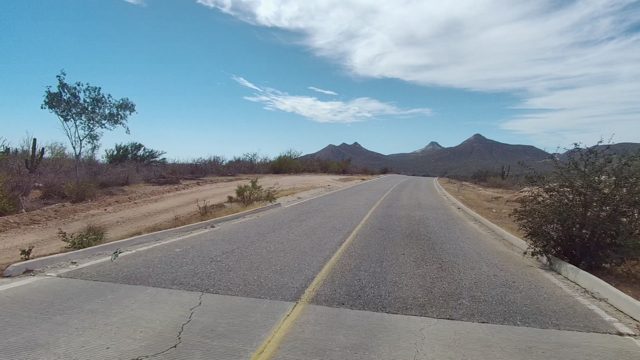 EAST CAPE LOS CABOS BCS MEXICO-2022: Paved Road Through Arid Landscape with Mountain Backdrop