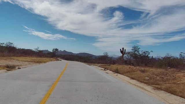 EAST CAPE LOS CABOS BCS MEXICO-2022: Winding Road Through Arid Landscape with Cacti and Mountains